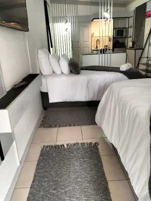 a hotel room with two beds and a rug at 20 on Middle in Polokwane