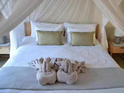 a bed with two pairs of towels on it at Empatia Lodge in Hoedspruit