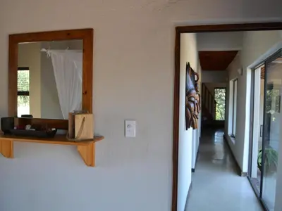a mirror on a wall next to a hallway at Empatia Lodge in Hoedspruit