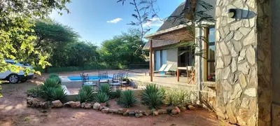 a house with a patio and a swimming pool at Empatia Lodge in Hoedspruit