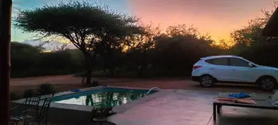 a white car parked next to a small pool at Empatia Lodge in Hoedspruit