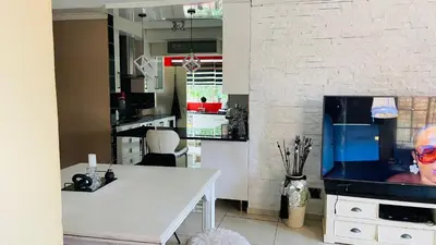 a kitchen with a table and a tv on a counter at Yvee Guesthouse in Hazyview