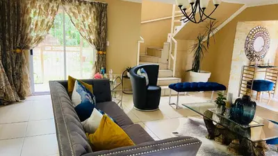a living room with a couch and a table at Yvee Guesthouse in Hazyview