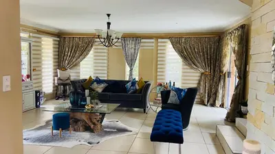 a living room with a couch and a table at Yvee Guesthouse in Hazyview