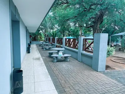 a row of benches sitting next to a building at Lantana Lodge in Phalaborwa