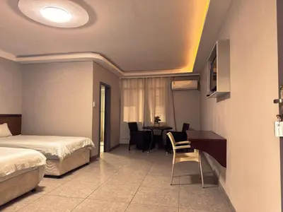a hotel room with two beds and a table and chairs at Lantana Lodge in Phalaborwa