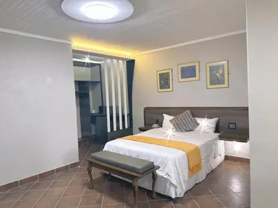 a bedroom with a bed and a bench in it at Lantana Lodge in Phalaborwa