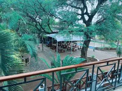 a view of a park with tables and a tree at Lantana Lodge in Phalaborwa