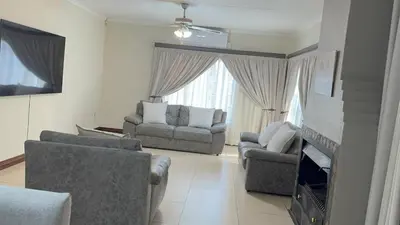 a living room with two couches and a tv at Home 11 Strydom in Nelspruit