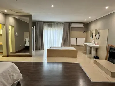 a large bathroom with a tub and a sink at Home 11 Strydom in Nelspruit