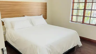 a bed with white sheets and pillows in a bedroom at Home 11 Strydom in Nelspruit
