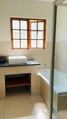 a bathroom with a sink and a tub and a window at Home 11 Strydom in Nelspruit