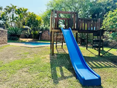 a playground with a blue slide in a yard at Home 11 Strydom in Nelspruit