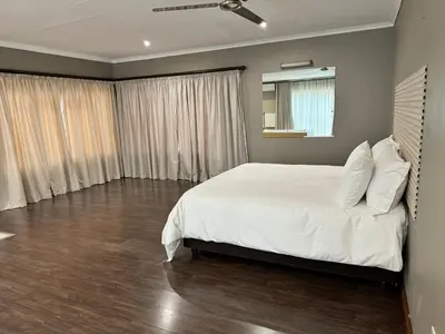 a bedroom with a large bed with white sheets and pillows at Home 11 Strydom in Nelspruit