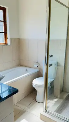 a bathroom with a toilet and a tub and a sink at Home 11 Strydom in Nelspruit