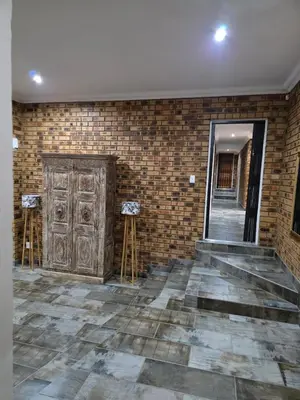 a room with a brick wall and a wooden door at Rocky Mountain Holiday Home in Hartbeespoort