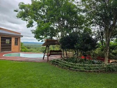 a yard with a swimming pool and a house at Rocky Mountain Holiday Home in Hartbeespoort