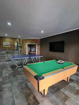 a living room with a pool table and a tv at Rocky Mountain Holiday Home in Hartbeespoort