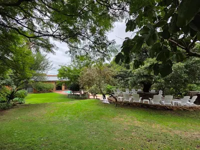 a row of white chairs sitting in a park at Rocky Mountain Holiday Home in Hartbeespoort