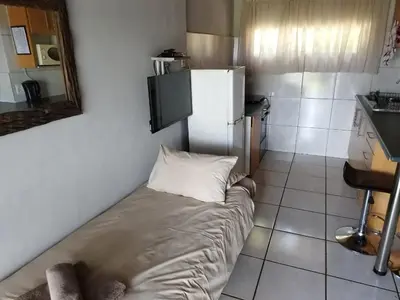 a small kitchen with a refrigerator and a pillow at Panorama home 19 in Graskop