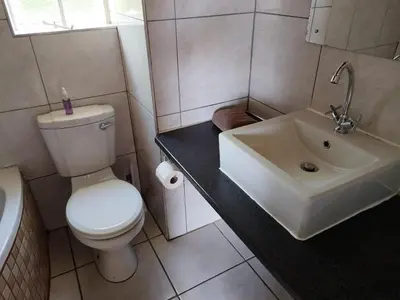 a bathroom with a white toilet and a sink at Panorama home 19 in Graskop