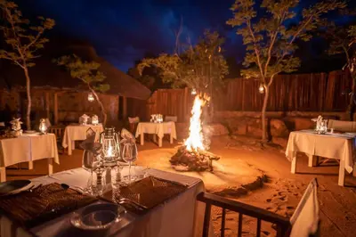a table set up for a wedding with a bonfire at Tshwene Lodge in Welgevonden Game Reserve