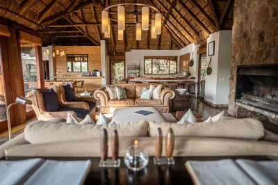a living room with couches and a fireplace at Tshwene Lodge in Welgevonden Game Reserve