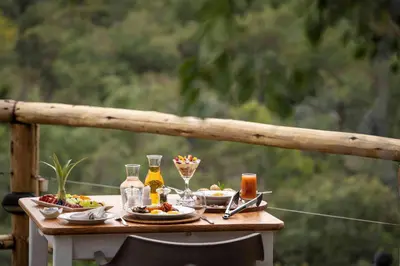 a table with plates of food and drinks on it at Tshwene Lodge in Welgevonden Game Reserve