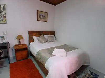 a bedroom with a bed with two towels on it at Millenium Manor Executive Homes in Centurion