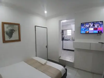 a white room with a bed and a flat screen tv at Millenium Manor Executive Homes in Centurion