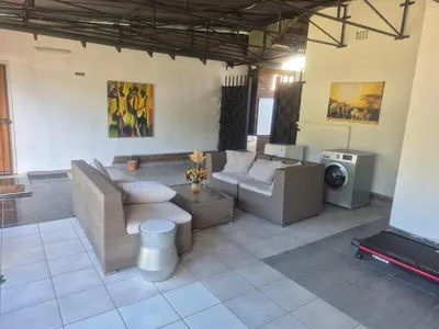 a living room with couches and a flat screen tv at Millenium Manor Executive Homes in Centurion
