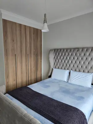 a bedroom with a large bed with a padded headboard at Views at The Blyde in Pretoria