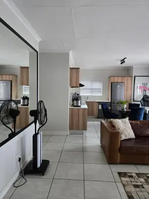 a living room with a couch and a kitchen at Views at The Blyde in Pretoria