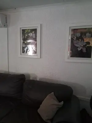 a living room with two pictures on the wall and a couch at Simunye Retreat in White River