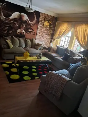a living room with a couch and a bulls head on the wall at Simunye Retreat in White River