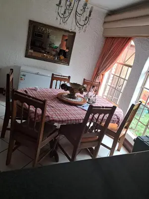 a dining room table and chairs with a table and a window at Simunye Retreat in White River