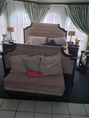 a large bed with a couch with pillows on it at Simunye Retreat in White River