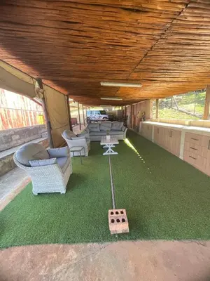a living room with a table and chairs and a game controller at Shyalongubo dam cabin in Barberton
