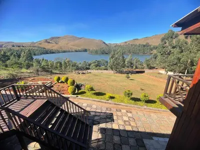 a bench on a porch with a view of a lake at Shyalongubo dam cabin in Barberton