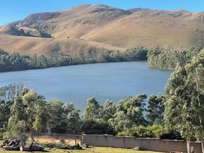 a large body of water with mountains in the background at Shyalongubo dam cabin in Barberton