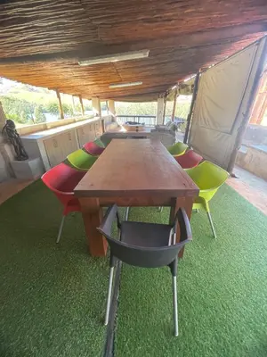 a table and chairs in a room with a tent at Shyalongubo dam cabin in Barberton