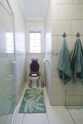 a bathroom with a toilet and a glass shower at Ryneveld Rest in Centurion