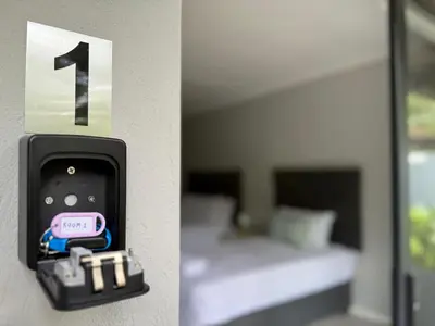 a wall mounted alarm clock in a room with a bed at Nelspruit Modern Apartment #1 - Self Check-In in Nelspruit