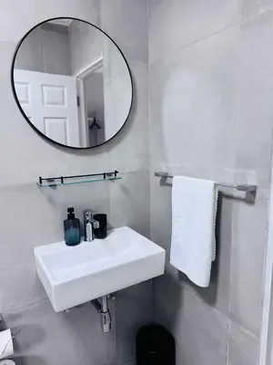 a bathroom with a white sink and a mirror at Nelspruit Modern Apartment #1 - Self Check-In in Nelspruit