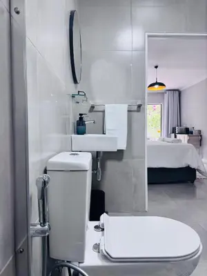 a bathroom with a toilet and a sink and a bed at Nelspruit Modern Apartment #1 - Self Check-In in Nelspruit
