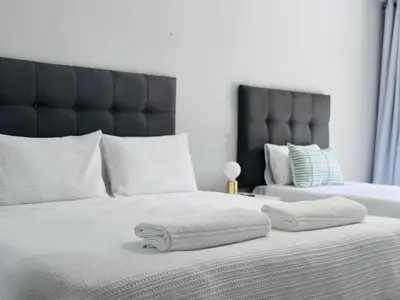 a bedroom with a bed with two towels on it at Nelspruit Modern Apartment #1 - Self Check-In in Nelspruit