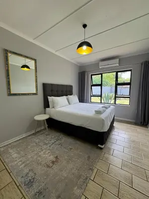 a bedroom with a large bed and a mirror at Nartjie - Apartment #3 in Nelspruit