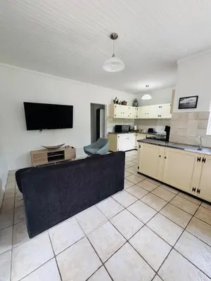a kitchen with a couch and a tv in a room at Nartjie - Apartment #3 in Nelspruit