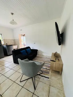 a living room with a couch and a chair at Nartjie - Apartment #3 in Nelspruit