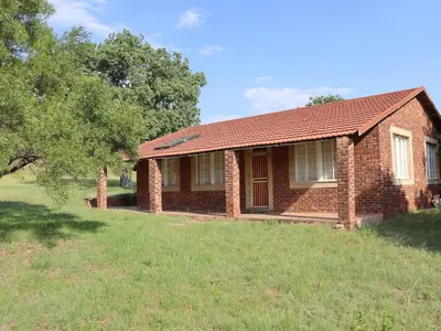 a small brick house with a grassy yard at Guesthouse in the Waterberg in Ouklip